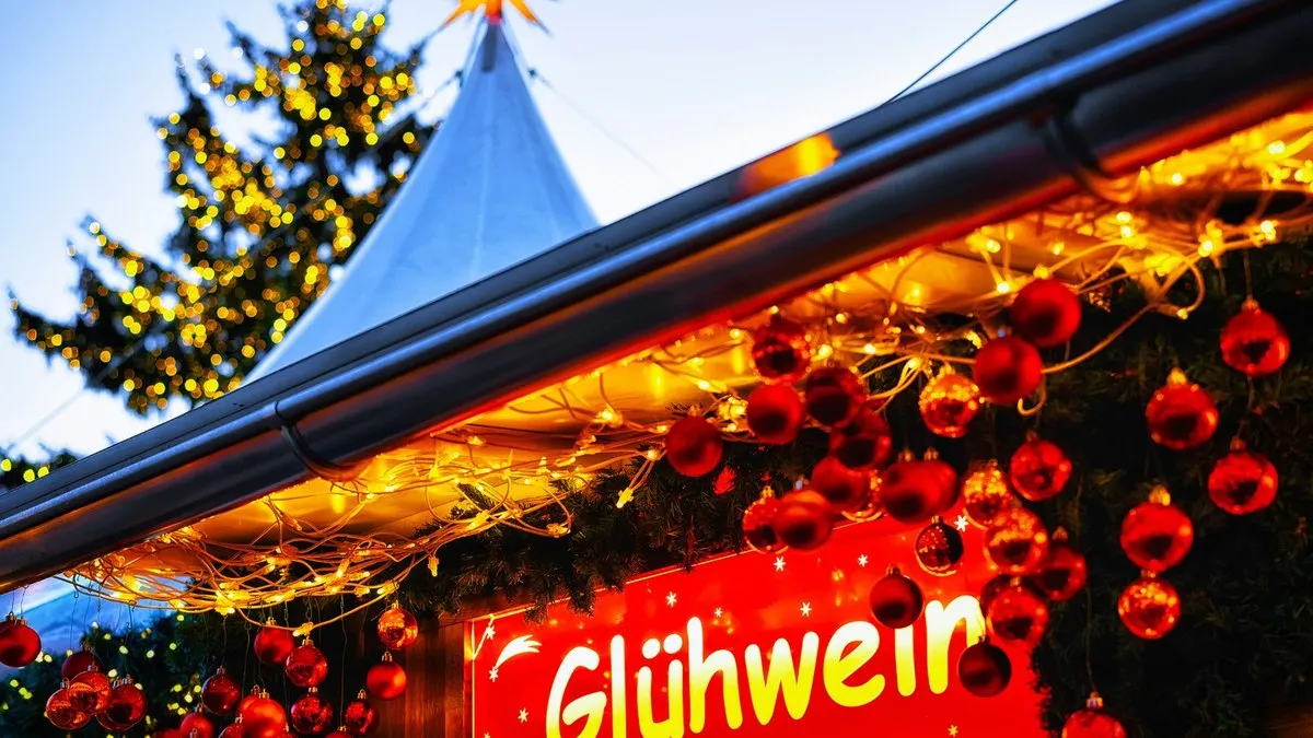 Üzerinde Glühwein yazan ışıklı Noel pazarı tezgahı