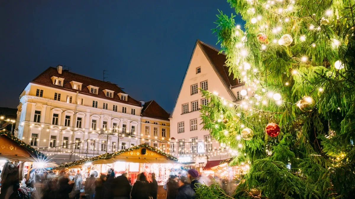 Tallinn Belediye Meydanı’nda Noel ağacı ve ahşap tezgahlar, gece